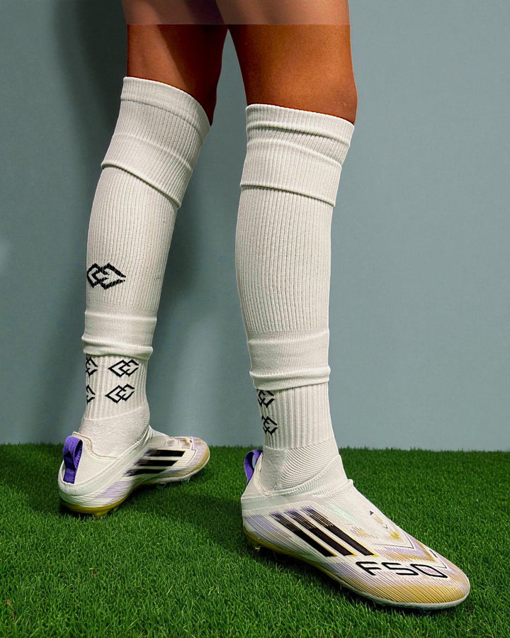 Player wearing white C3 pre-cut socks over white C3 grip socks on turf