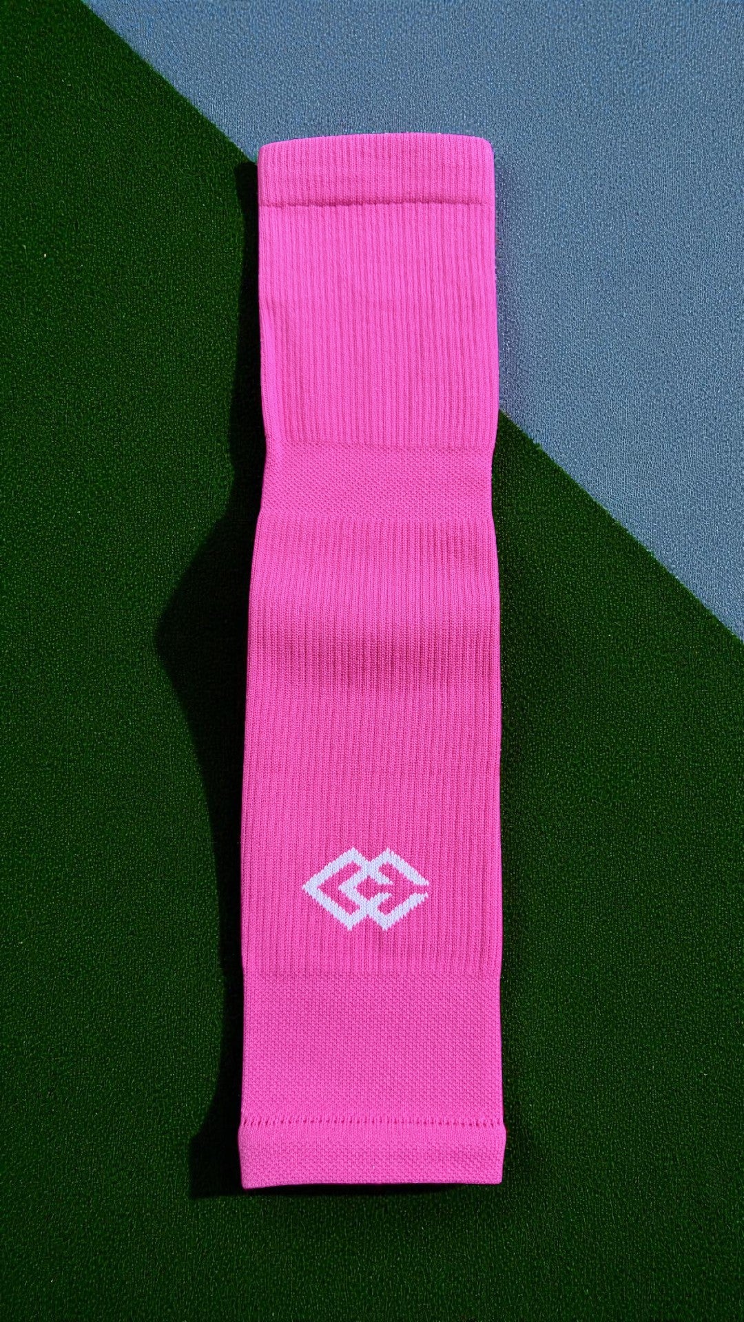 Single pink C3 pre-cut sock with a C3 logo laid flat on green turf