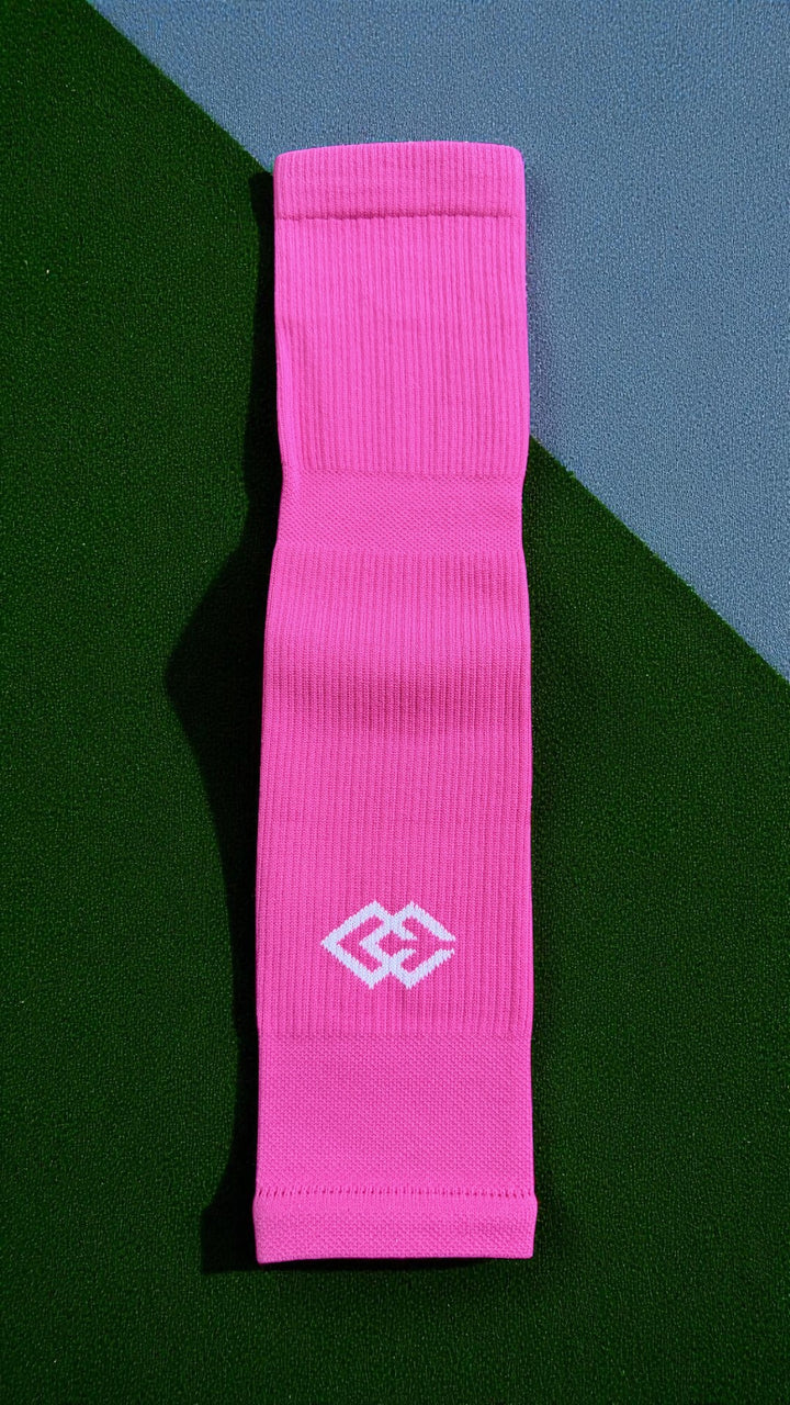Single pink C3 pre-cut sock with a C3 logo laid flat on green turf